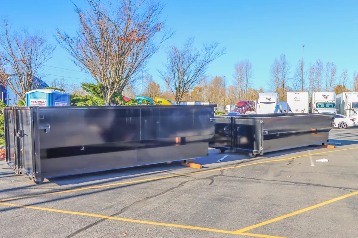 Professional dumpster rental service with roll-off container on residential driveway in Bay Minette